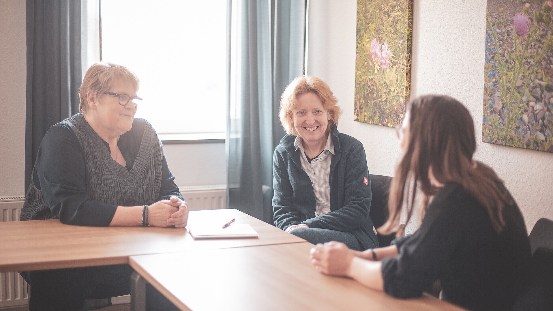 Anne Huxel und Bettina Beusing mit einer Frau in einer Beratungssituation